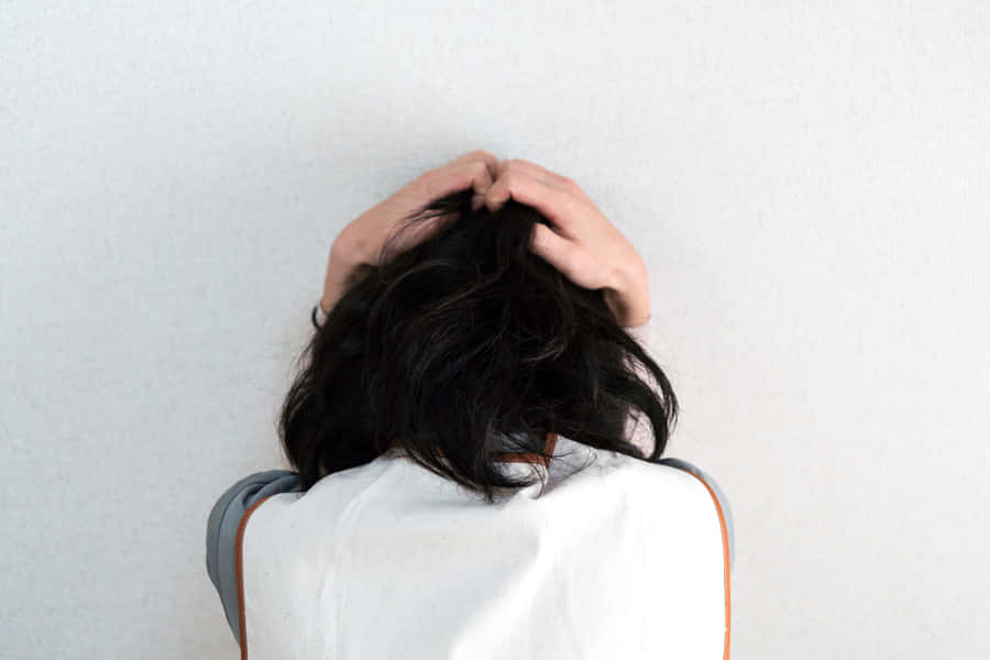 Anxious Person Clutching Head Wallpaper