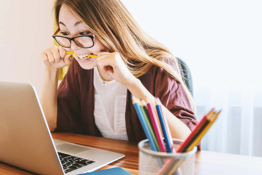 Anxious Woman Biting Pencil While Working Wallpaper