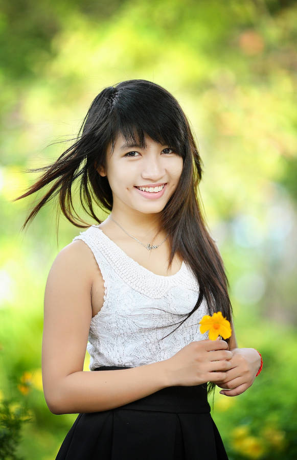 Asian Woman With A Yellow Flower Wallpaper
