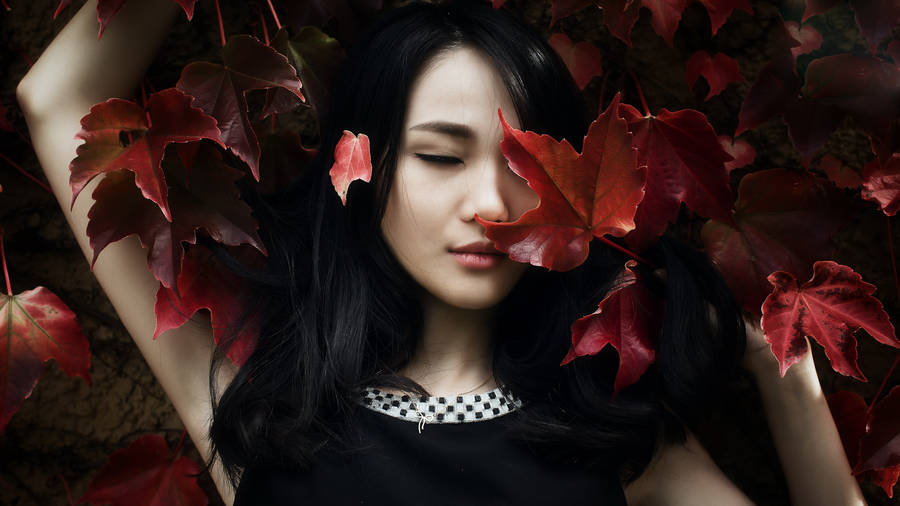 Asian Women Lying On Red Leaves Wallpaper