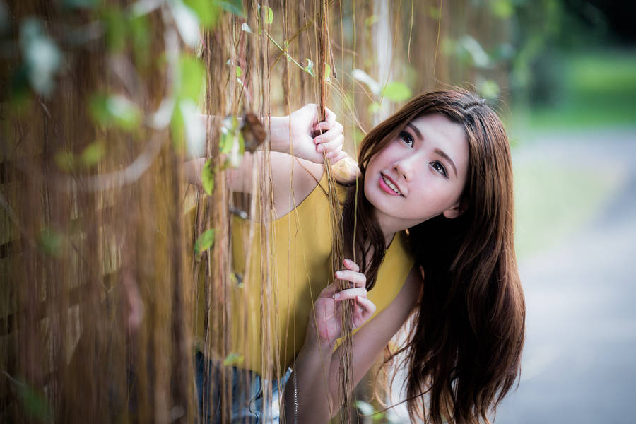 Asian Women Peeking Through Vines Wallpaper