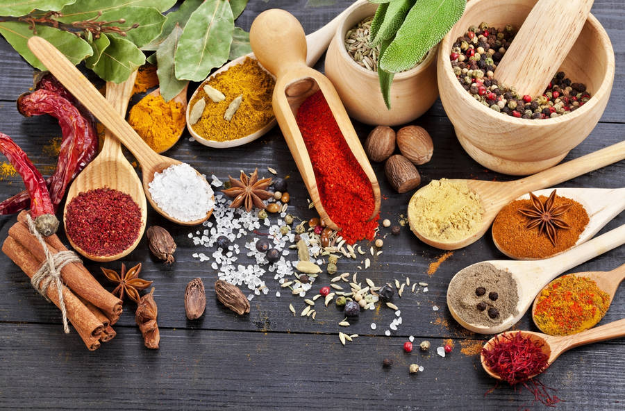 Assortment Of Spices Amidst Wooden Utensils Wallpaper