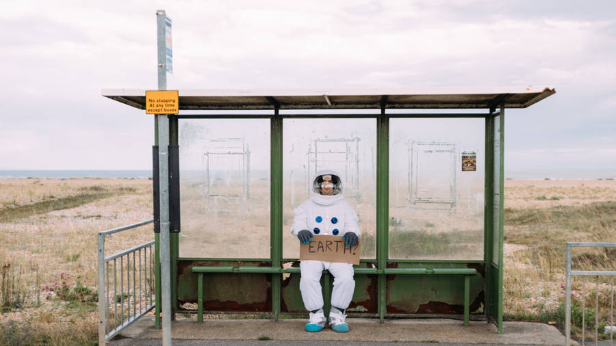 Astronaut At Bus Stop Wallpaper