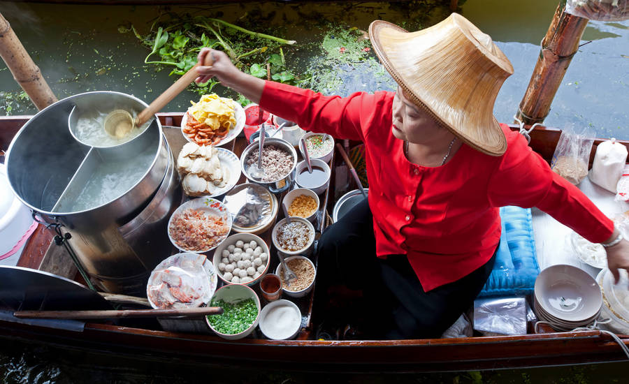 Authentic Flavors Of Bangkok - A Food Stall At A Floating Market Wallpaper