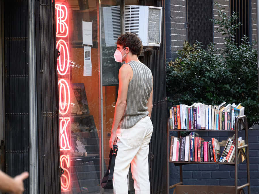 Avid Reader Exploring A Local Book Store Wallpaper