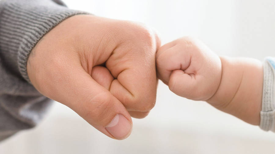 Baby Hand Fist Bumping With Dad Wallpaper