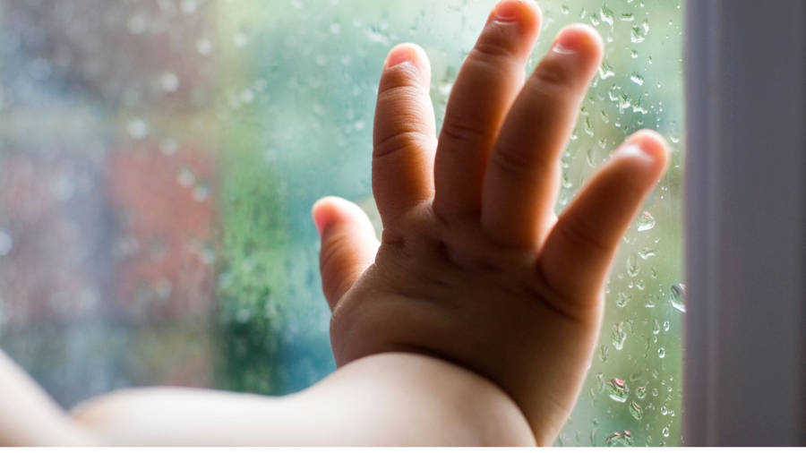 Baby Hand Leaning On Glass Panel Wallpaper