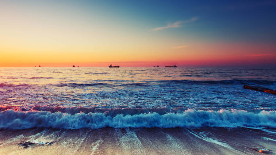 Beautiful Beach With Ships In The Distance Wallpaper