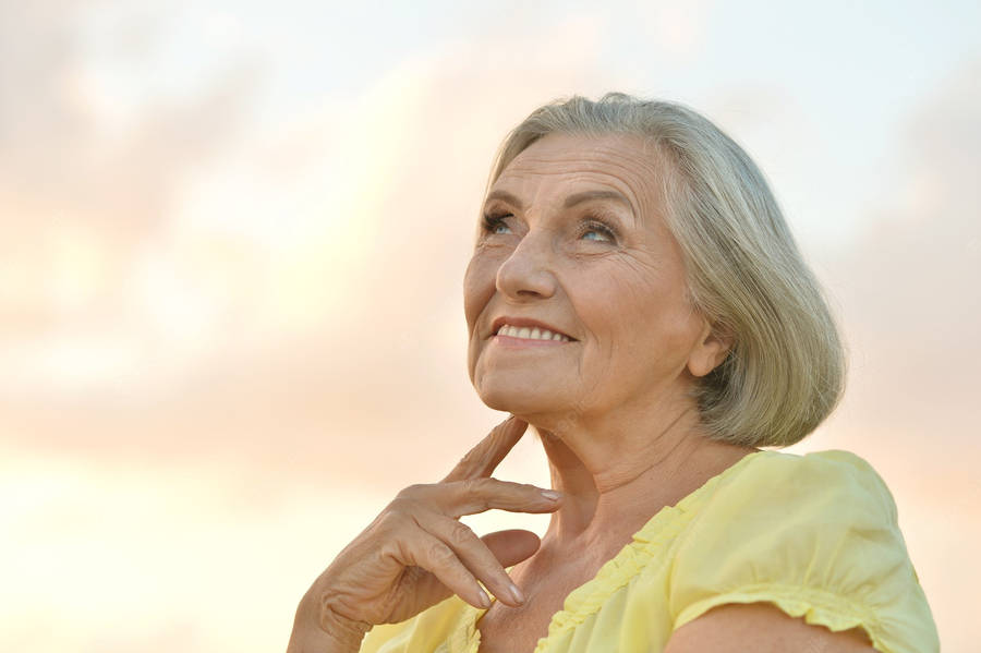 Beautiful Older Woman Yellow Top Wallpaper