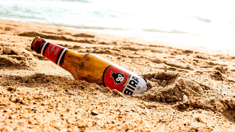 Beer Bottle Buried On The Sand Wallpaper