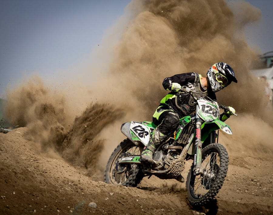 Bike Rider With Dirt Clouds Behind Him Wallpaper