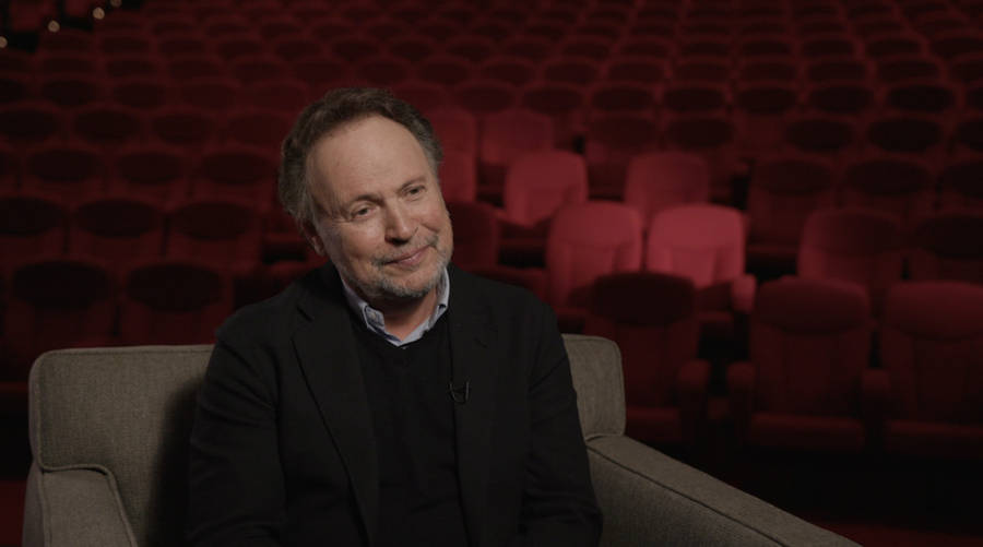 Billy Crystal During An Interview In An Ornate Movie Theatre Wallpaper