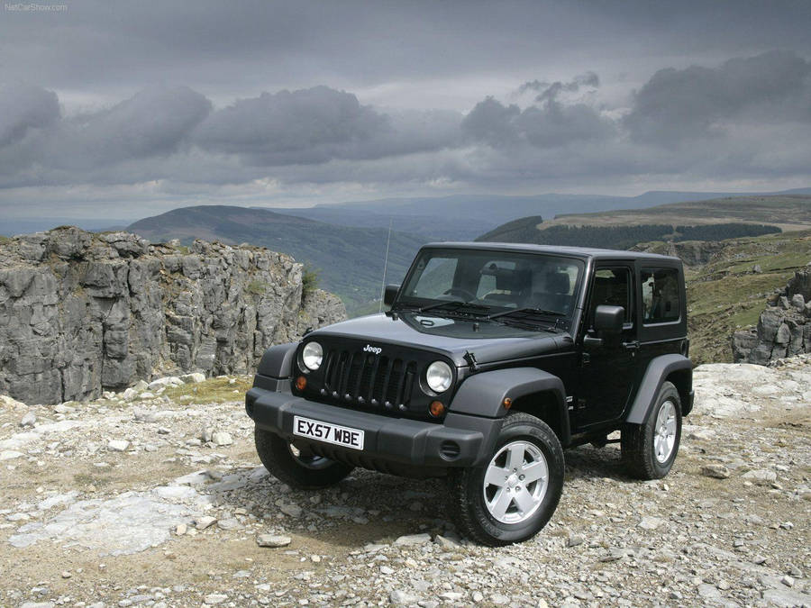 Black Jeep Wrangler On Rocky Cliff Wallpaper