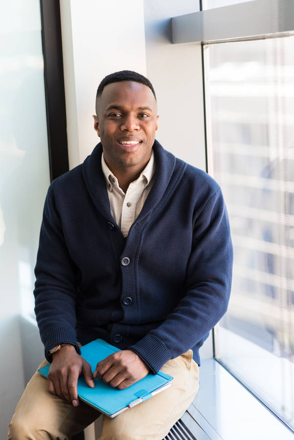 Black Man With Navy Blue Knitted Sweater On Wallpaper