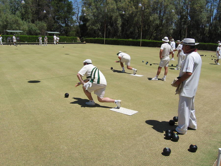 Bocce Ball Players In White On Grass Wallpaper