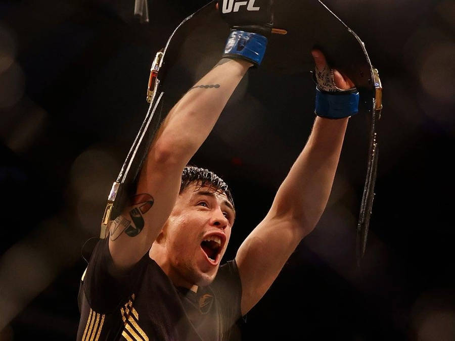 Brandon Moreno Holding Up Championship Belt Wallpaper