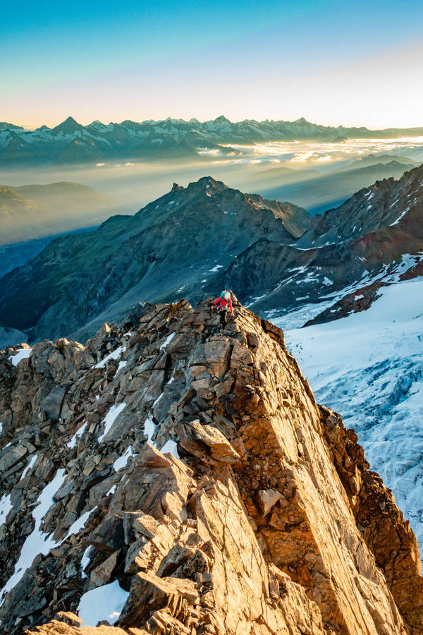 Bravely Exploring The Peaks Of The World Wallpaper