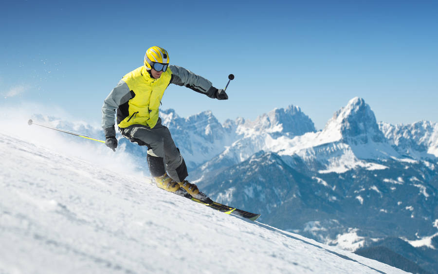 Breathtaking Alpine Skiing Adventure In The Snowy Mountains Wallpaper