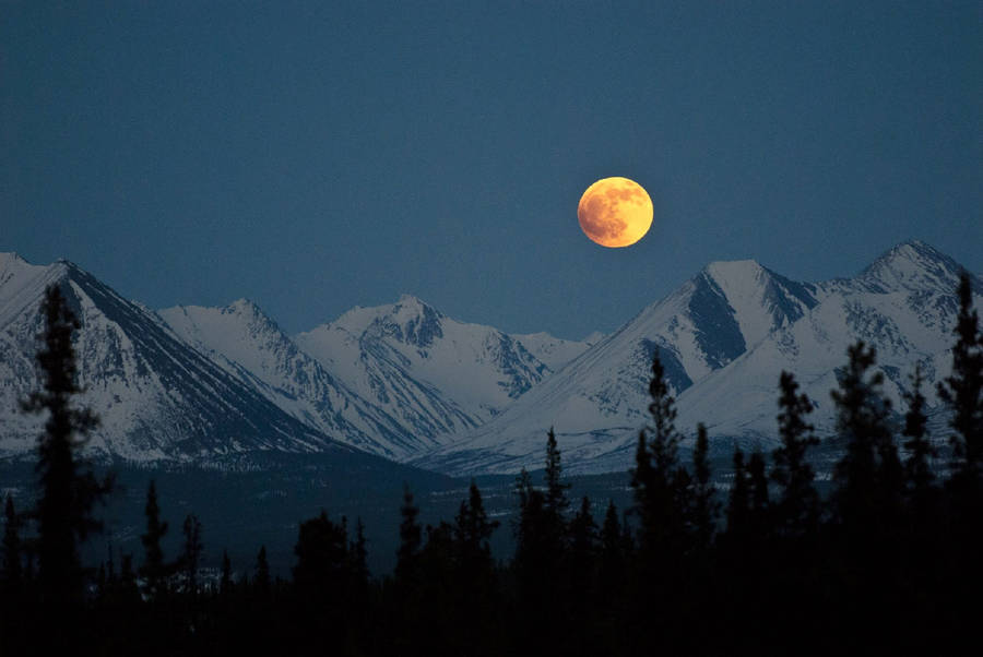 Breathtaking View Of A Full Moon Over Denali Mountains Wallpaper