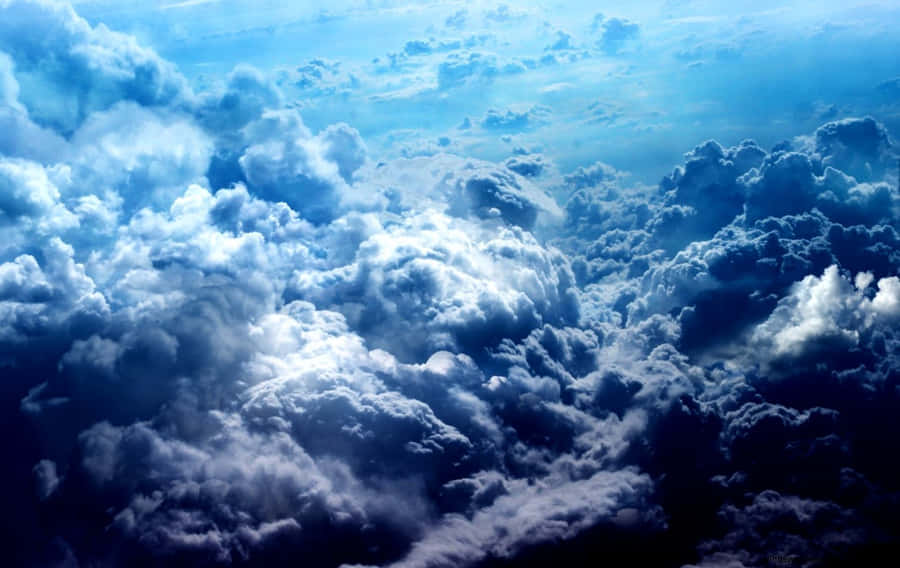 Brilliant Blue Skies Contrasted With Softly Billowing White Clouds Form A Sublimely Peaceful Paradise. Wallpaper