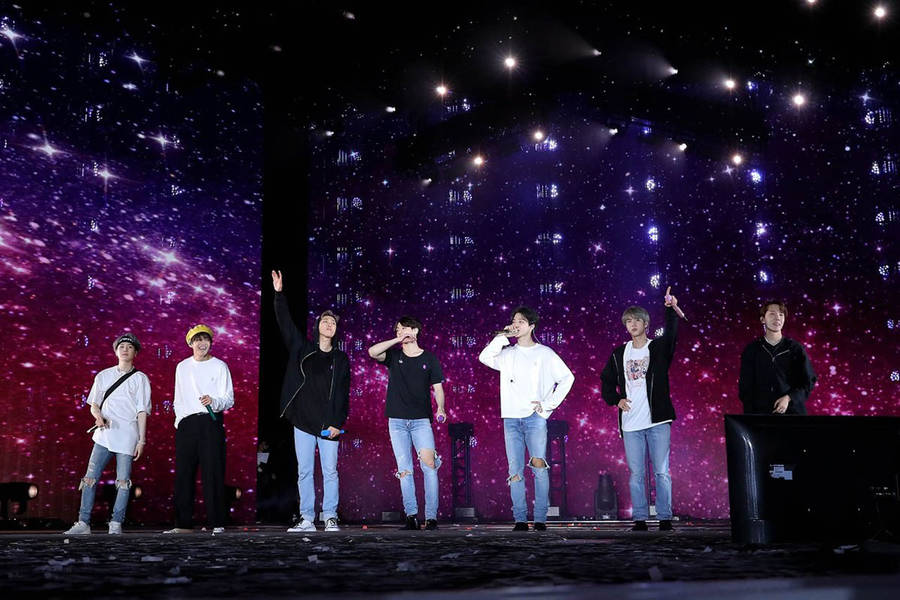 Bts Illuminating The Concert With Their Magnetic Performance Wallpaper