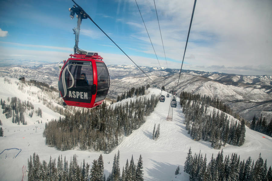 Caption: Aspen Gondola Ride Against A Majestic Red Sky Wallpaper