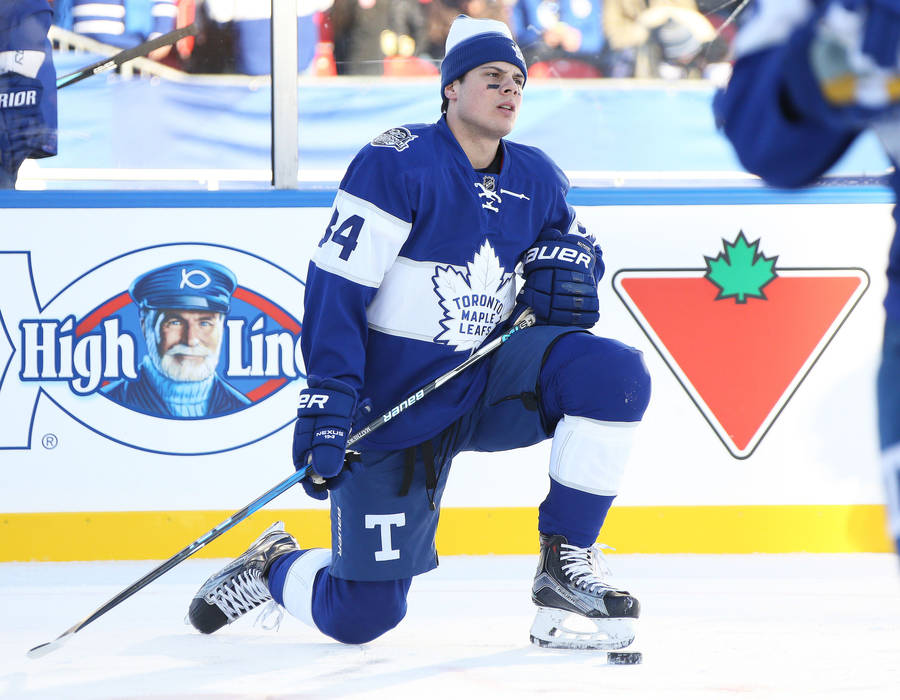 Caption: Auston Matthews Kneeling On Ice Wallpaper