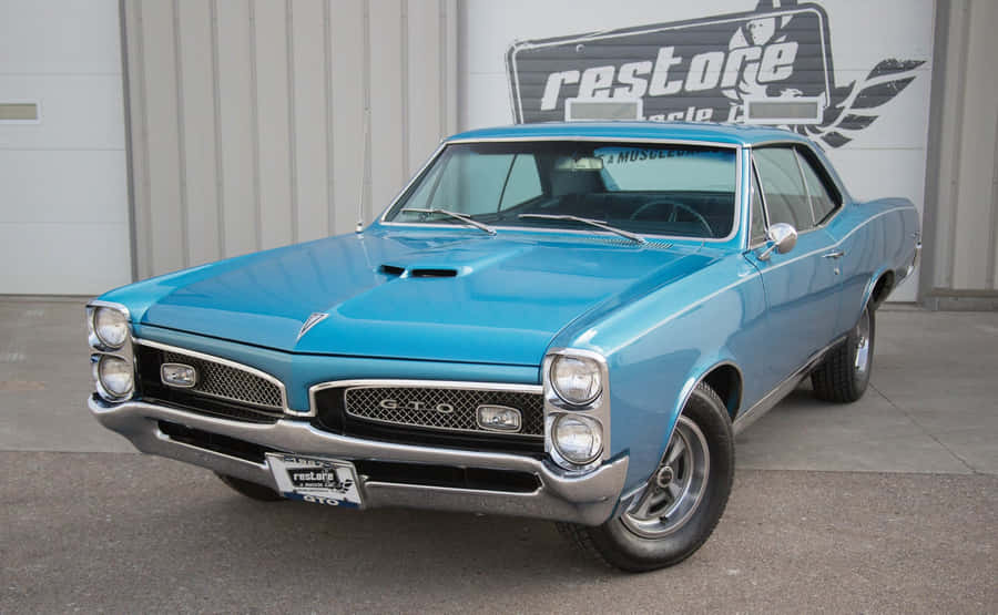 Caption: Classic Pontiac Gto Muscle Car In Action Wallpaper