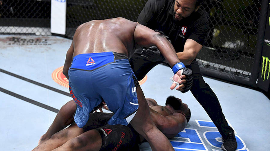 Caption: Curtis Blaydes Demonstrating Strength Against An Opponent In The Ring Wallpaper