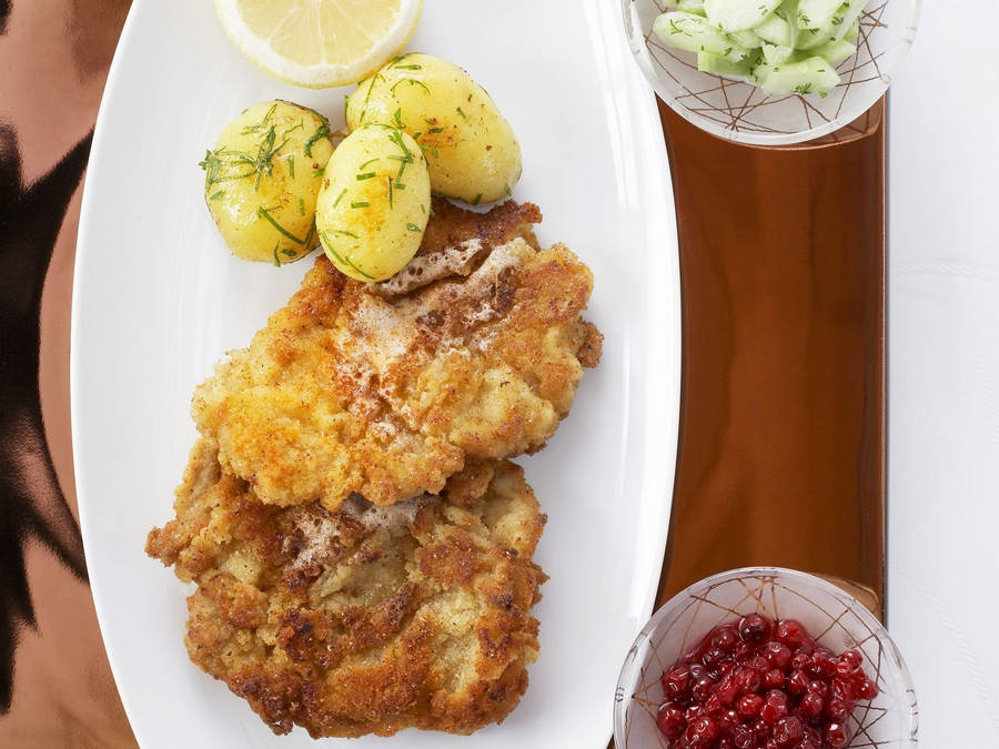 Caption: Delectable Wiener Schnitzel Served With Tasty Marble Potatoes Wallpaper