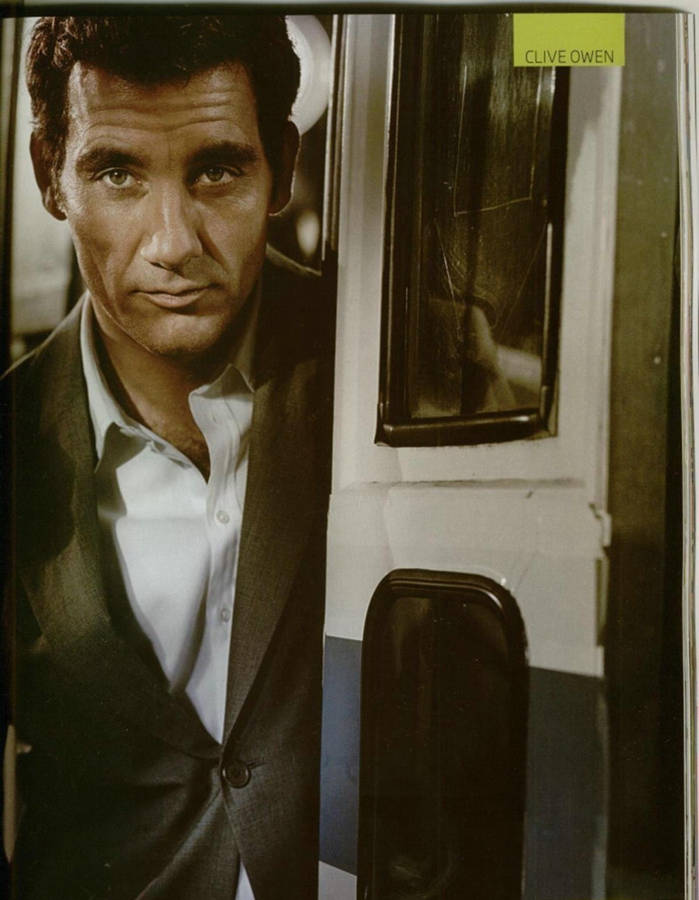 Caption: English Actor Clive Owen Posing By The Door Wallpaper