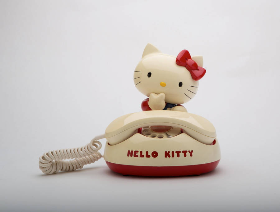 Caption: Interactive Hello Kitty At Desk With Telephone Wallpaper Wallpaper