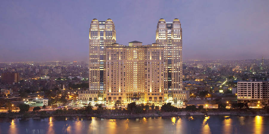 Caption: Mesmerizing View Of The Fairmont Nile City Cairo Hotel At Sunset Wallpaper