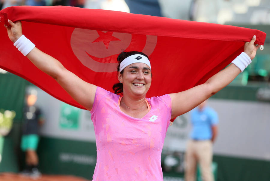 Caption: Ons Jabeur Holds High The Tunisian Flag In Celebration Wallpaper