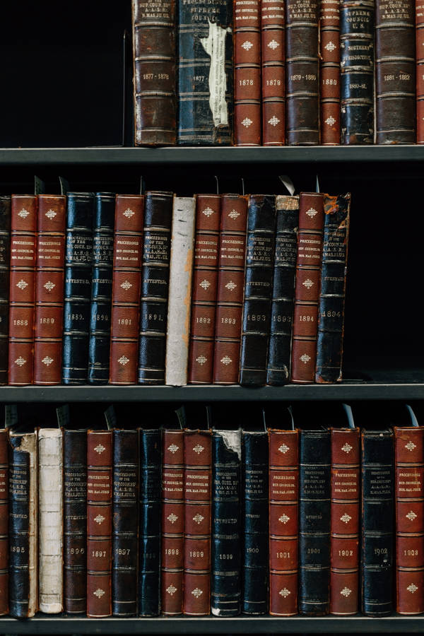 Caption: Organized Collection Of Books On Shelves Wallpaper