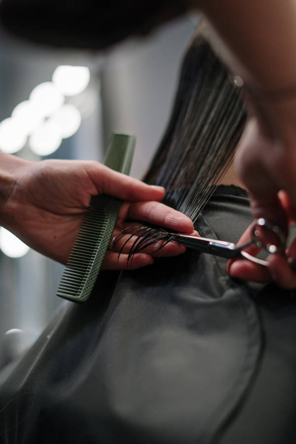 Caption: Professional Hairstylist At Work In Modern Beauty Salon Wallpaper