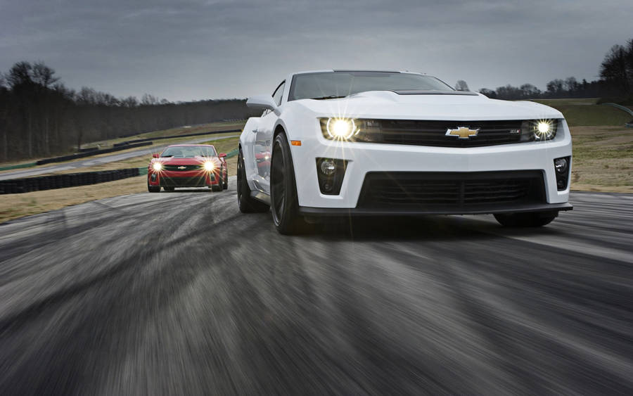 Caption: Striking Speed - A Chevrolet Camaro Muscle Car In Its Racing Glory Wallpaper