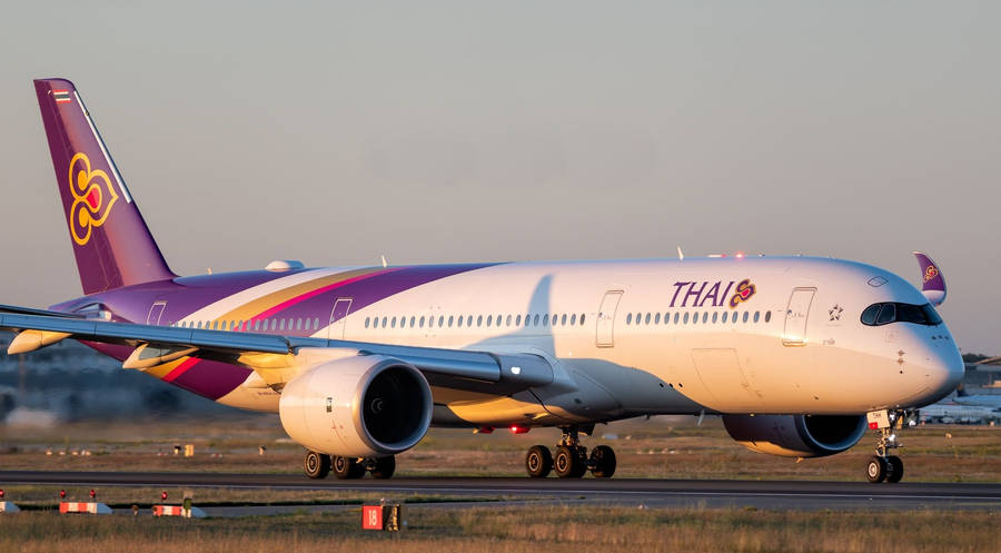 Caption: Thai Airways Airliner Landing On Runway Wallpaper