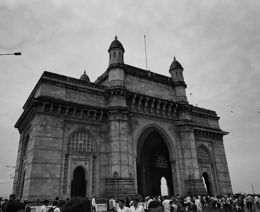 Caption: The Majestic Gateway Of Mumbai Under Ambient Skies Wallpaper