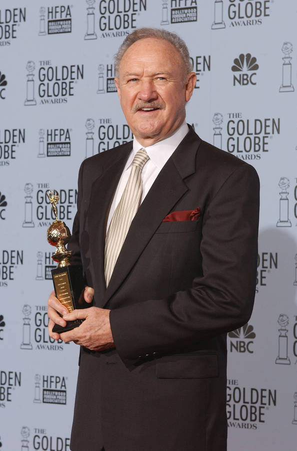 Celebrated Actor Gene Hackman Holding Prestigious Award Wallpaper