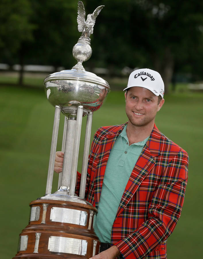 Champion Golfer Chris Kirk Holding A Huge Trophy Wallpaper