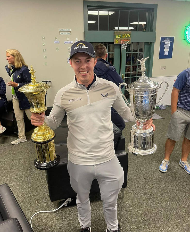 Champion Golfer Matt Fitzpatrick Enjoys His Victory By Holding Two Trophies Wallpaper