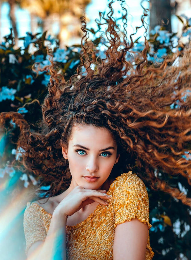 Charismatic Girl With Bountiful Curly Hair Wallpaper