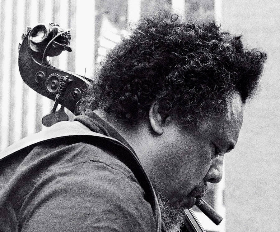 Charles Mingus Smoking While Carrying Bass Guitar Wallpaper