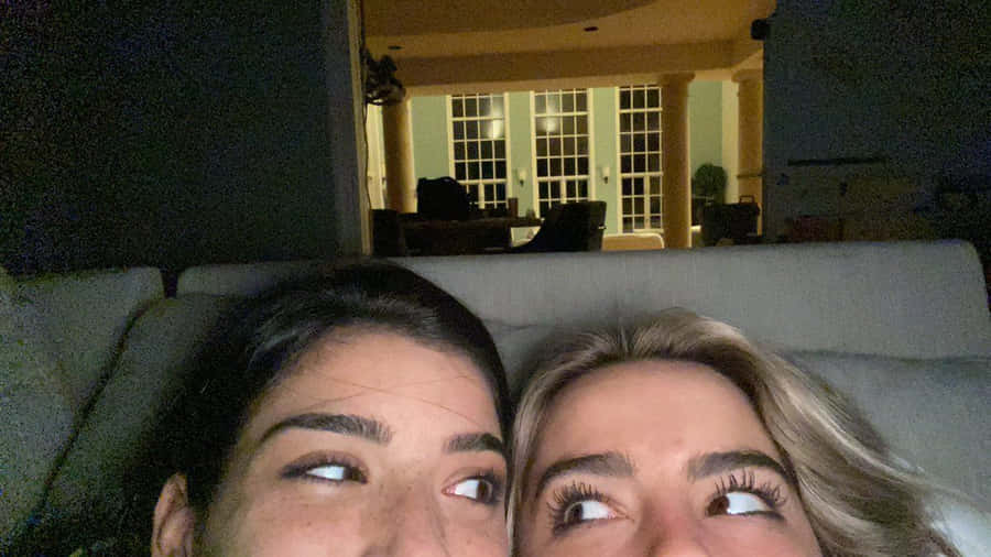 Charli And Addison Lying On A Couch Wallpaper