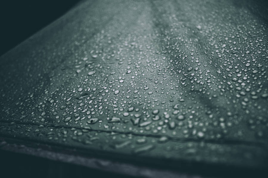 Close-up Of Glistening Water Droplets On A Reflective Surface Wallpaper