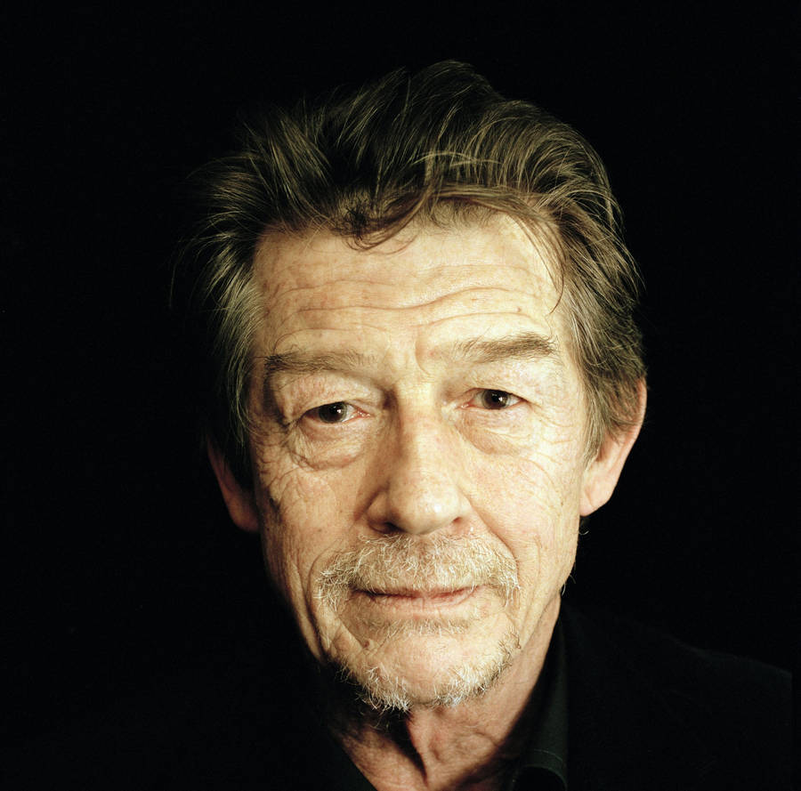 Close-up Portrait Of John Hurt Against A Black Backdrop Wallpaper