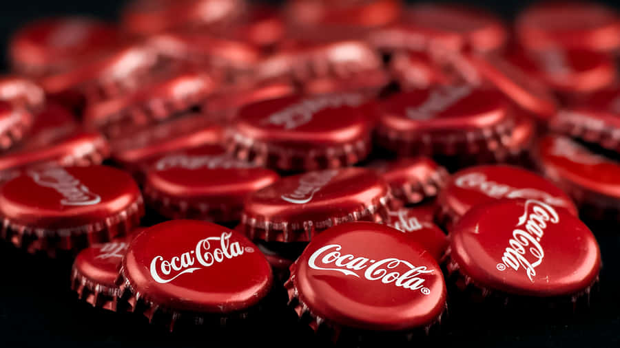 Coca Cola Bottle Caps On A Black Background Wallpaper