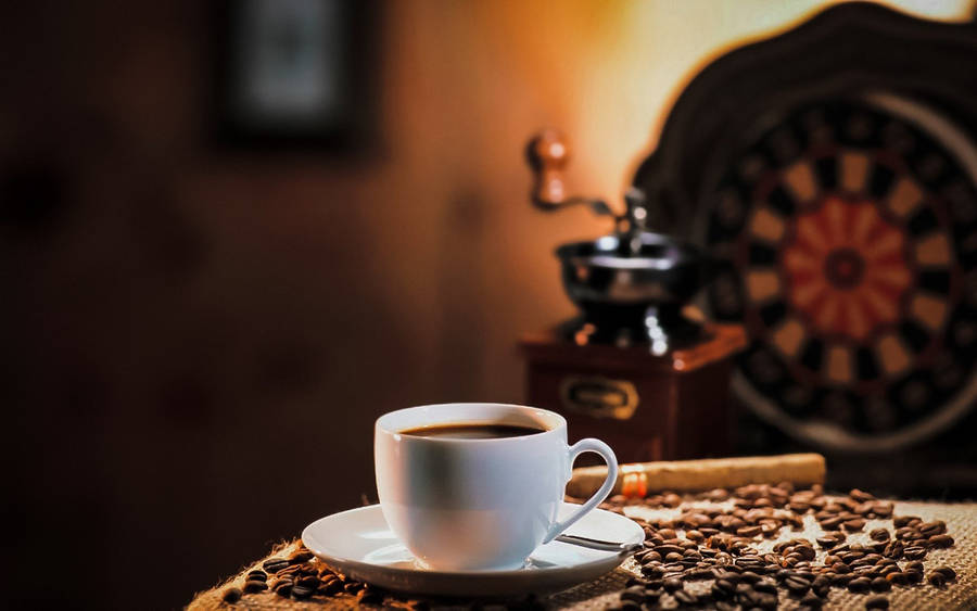 Coffee Cup With Coffee Beans And A Grinder Wallpaper