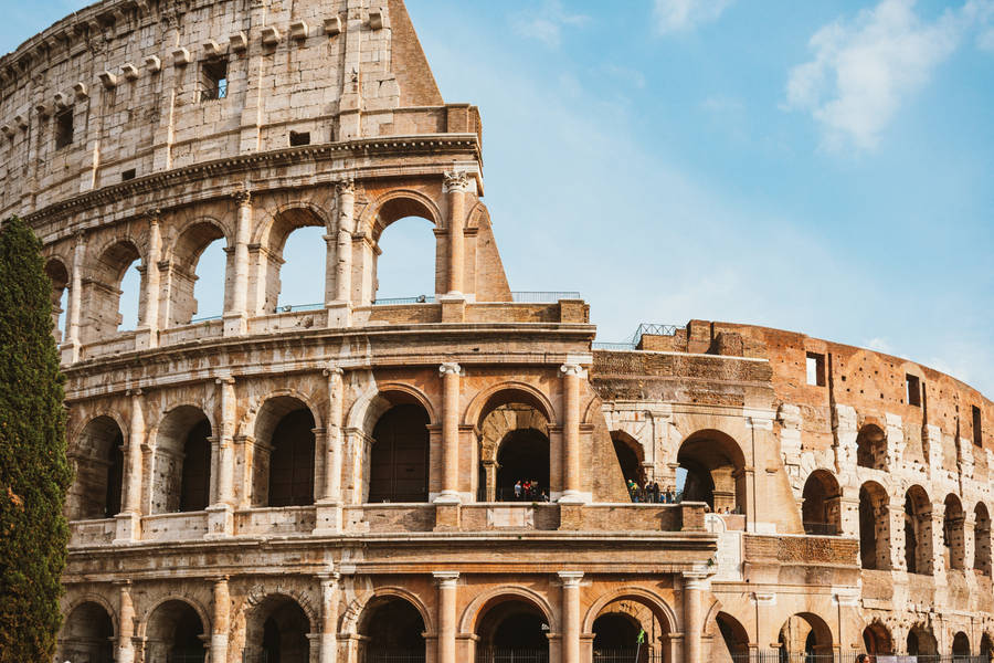 Colosseum Ruins In Front Of A Cloudy Sky Wallpaper